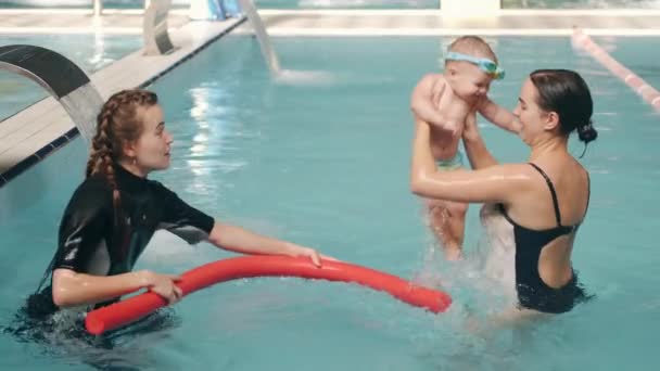 Mutter und Säugling beim Schwimmunterricht mit Lehrerin — Stockvideo