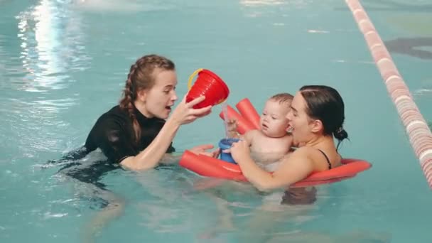 Mãe e filho bebê na aula de natação com instrutora — Vídeo de Stock