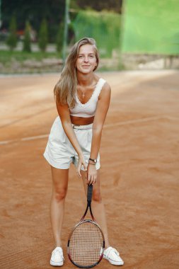 Yaz tenis kortunda şık bir kadın.