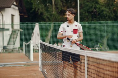 Yaz tenis kortunda yakışıklı bir adam.