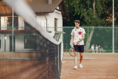 Yaz tenis kortunda yakışıklı bir adam.