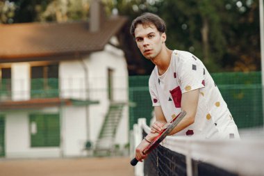 Yaz tenis kortunda yakışıklı bir adam.