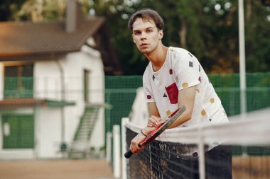 Yaz tenis kortunda yakışıklı bir adam.