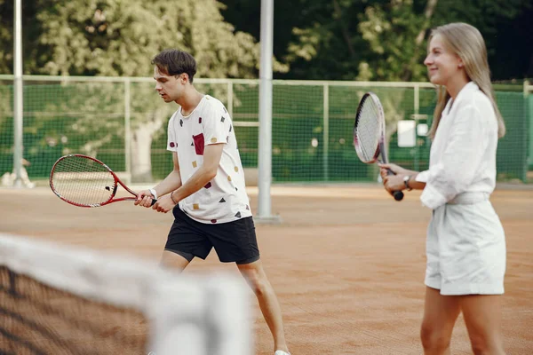 Pár hrát tenis hry venku — Stock fotografie