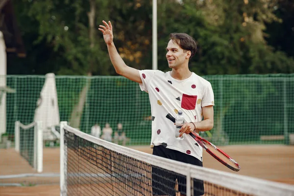 Yaz tenis kortunda yakışıklı bir adam.