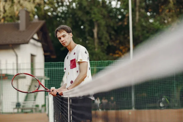 Snygg man på en sommartennisbana — Stockfoto