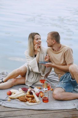 İnsanlar piknik setiyle suyun kenarında oturuyorlar.