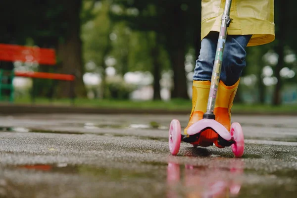 Niños divertidos en botas de lluvia jugando con patines —  Fotos de Stock