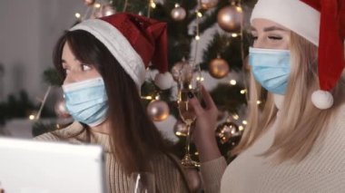 Kız arkadaşlar Noel 'i kutluyor ve tablette video çağrısı yapıyor.