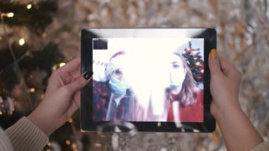Kız arkadaşlar Noel 'i kutluyor ve tablette video çağrısı yapıyor.