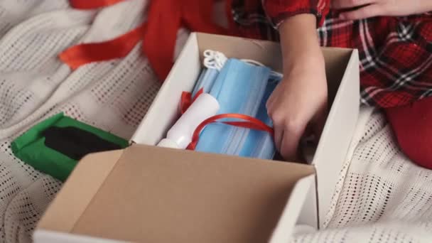 Chica sacando máscaras médicas de color azul claro empaquetado en caja de regalo — Vídeo de stock