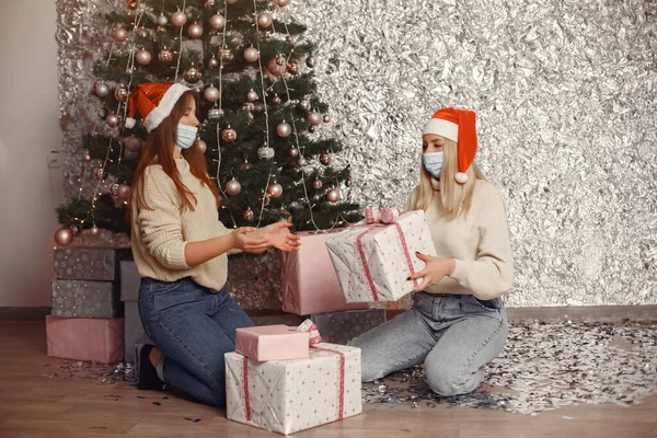 Two women decorate Christmas gifts with medical masks — Stock Photo, Image