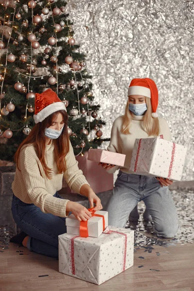 Dos mujeres decoran regalos de Navidad con máscaras médicas — Foto de Stock