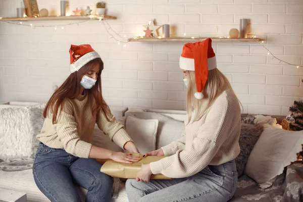 Two women decorate Christmas gifts with medical masks — Stock Photo, Image