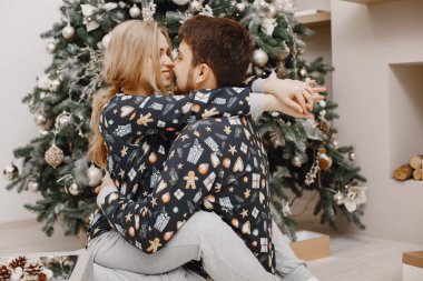 Evde Noel ağacının yanında sevimli bir çift var.