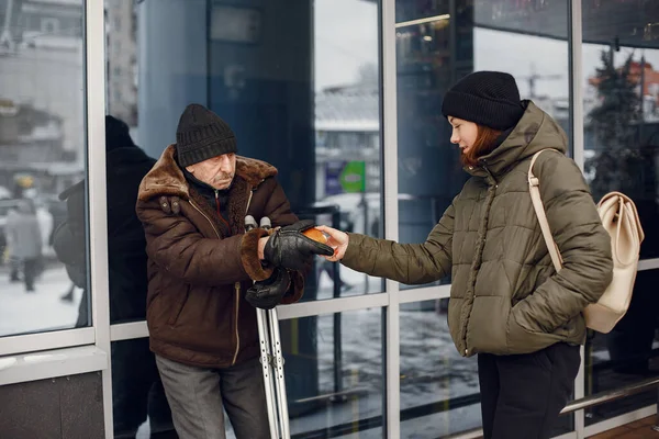 Disabled homeless man on crutches in old clothes