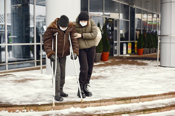 Disabled homeless man on crutches in old clothes