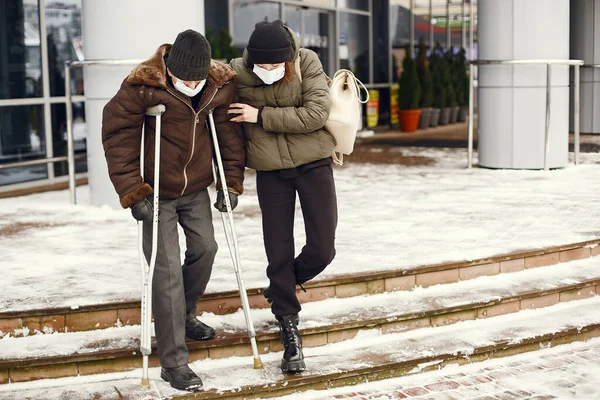 Disabled homeless man on crutches in old clothes