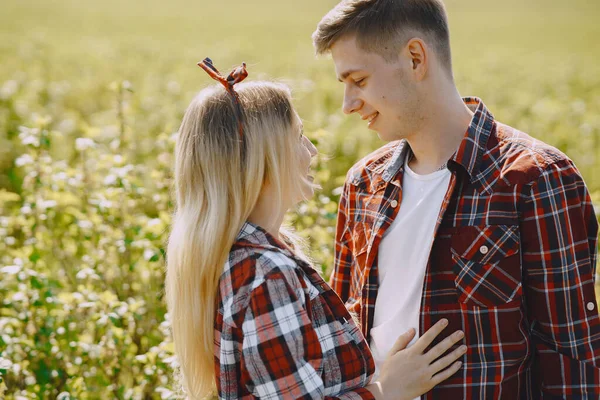 Junger Mann und Frau in einem Sommerfeld — Stockfoto