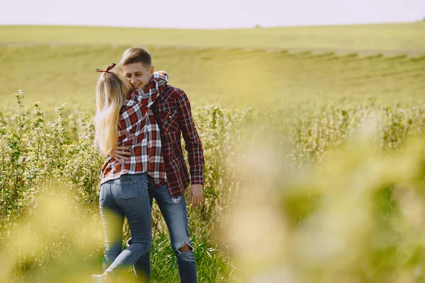 Joven pareja de hombres y mujeres en un campo de verano —  Fotos de Stock