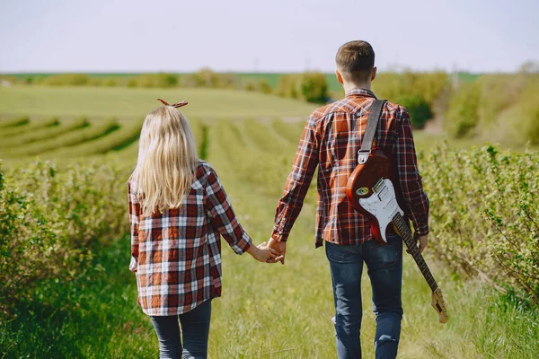 Ung man och kvinna par i ett sommarfält — Stockfoto