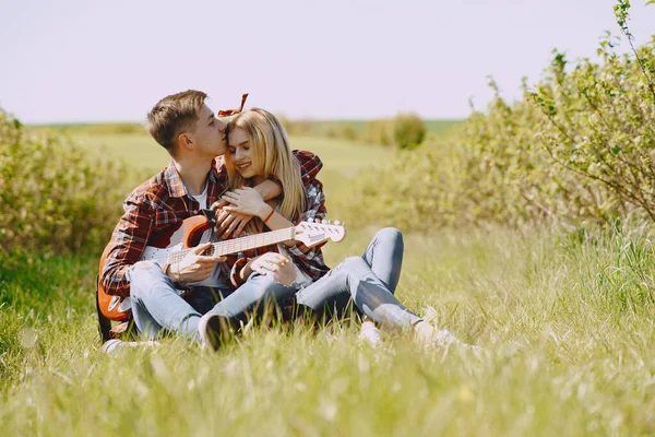 Ung man och kvinna par i ett sommarfält — Stockfoto