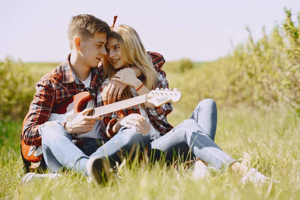 Ung man och kvinna par i ett sommarfält — Stockfoto