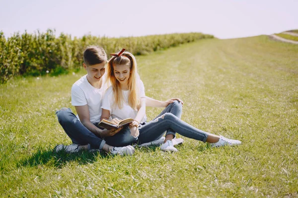 Ung man och kvinna par i ett sommarfält — Stockfoto