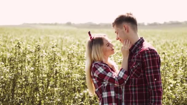 Homem e mulher num campo no dia de primavera. Casal apaixonado passar o tempo no campo de primavera. Grama no fundo. — Vídeo de Stock