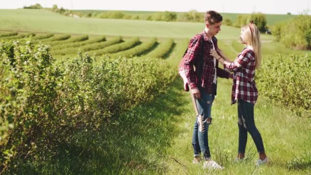 Мужчина и женщина в поле весной. Влюбленные проводят время на весеннем поле. Трава на заднем плане. Человек с электрогитарой. — стоковое видео