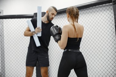 Boks eldivenli kendinden emin genç bir kadının portresi.