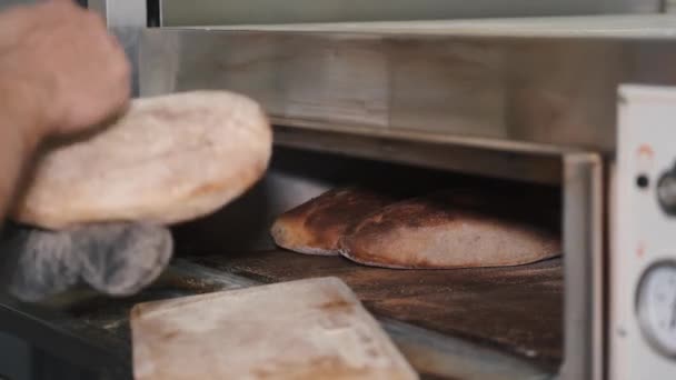 Baker homem verificando pão assar no forno — Vídeo de Stock