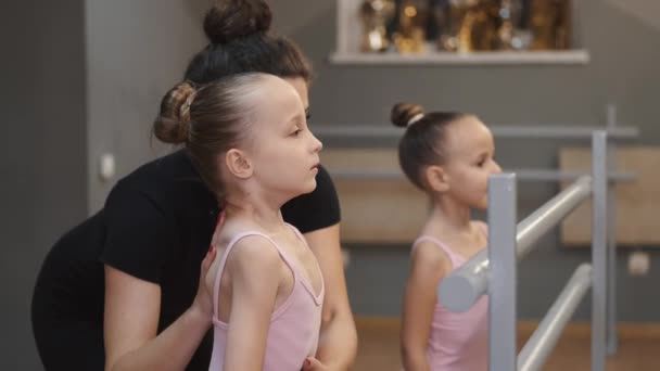 Ung lärare undervisar små ballerinor på en dansklass i studio — Stockvideo