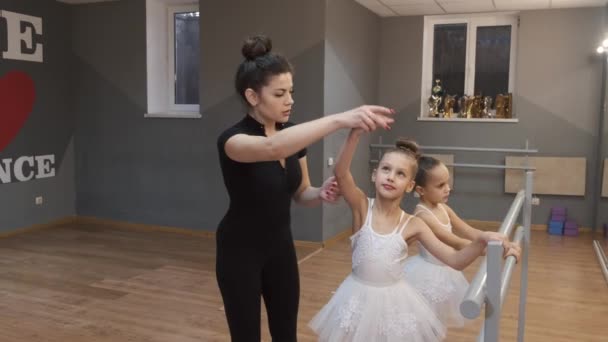 Jonge leraar onderwijzen kleine ballerina 's op een dansles in de studio — Stockvideo