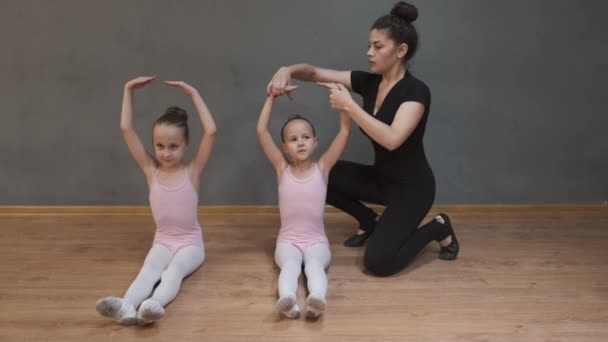 Professor de balé bailarina profissional ajudando meninas esticar — Vídeo de Stock