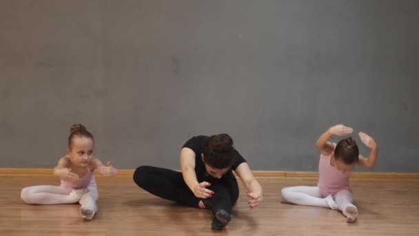 Ballettlehrerin professionelle Ballerina hilft Mädchen dehnen — Stockvideo