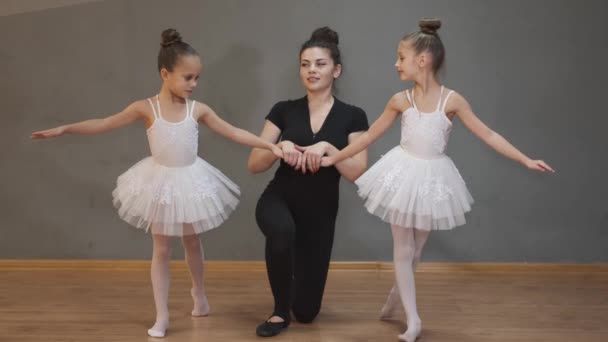 Bailarina profesional profesora de ballet ayudando a las niñas a estirarse — Vídeo de stock