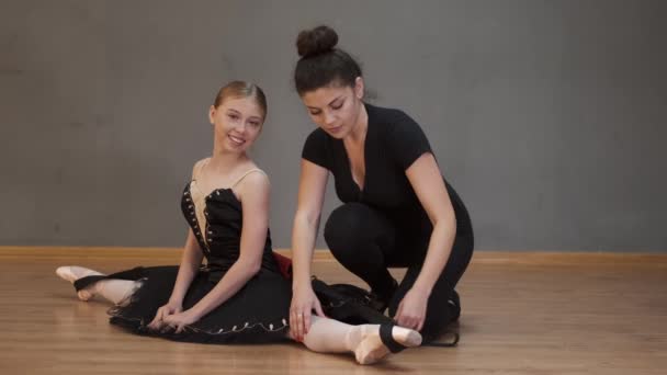 Ballettlehrerin hilft Mädchen vor Vorstellung beim Aufwärmen — Stockvideo