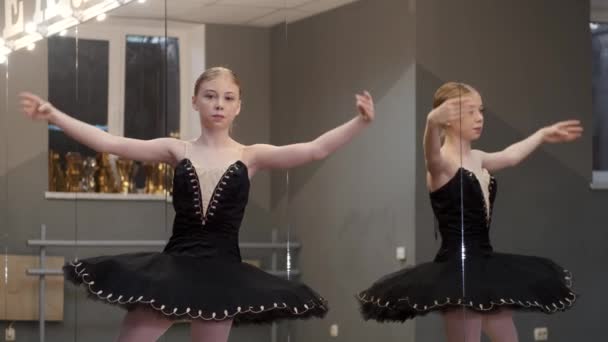 Jeune ballerine en jolie robe pratiquant dans un studio — Video