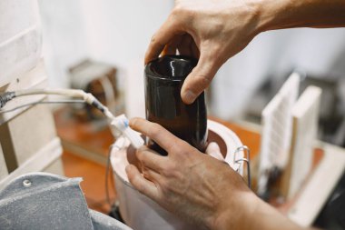 Bir adam şişeyi bardağa doldurur.