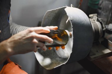 Bir adam şişeyi bardağa doldurur.