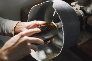 Bir adam şişeyi bardağa doldurur.