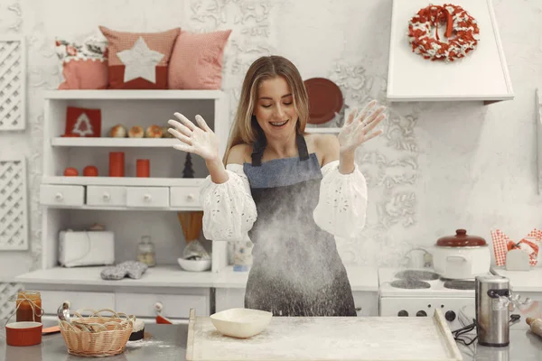 Mujer rubia sonriente preparando un pastel en una cocina — Foto de Stock
