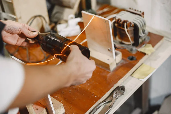 Bir adam şişeyi bardağa doldurur.