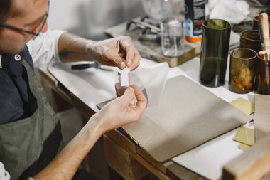 Bir adam gözlüklere etiket yapıştırır.