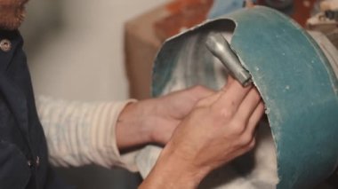 El sanatları adamı özel bir makinede siyah cam parlatıyor.