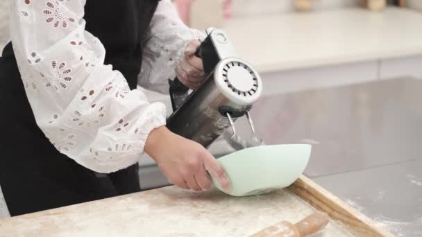 Jovem atraente no avental usando misturador na cozinha — Vídeo de Stock