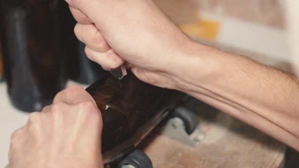 Homem de artesanato cortando garrafa de cerveja com uma ferramenta — Vídeo de Stock