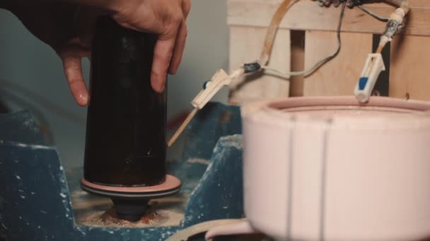 Crafts man is polishing dark glass in a special machine — Stock Video