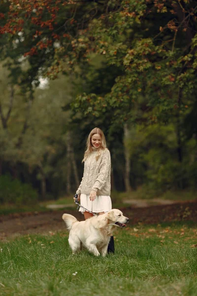 Mulher caminha na floresta de outono com um cão — Fotografia de Stock